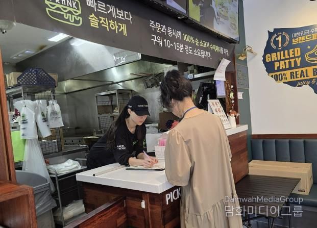 성남시 어린이 기호식품 전담관리원이 지난 9월 학교 주변 햄버거 판매점에서 영업자와 종업원의 건강진단 실시 여부를 점검하고 있다