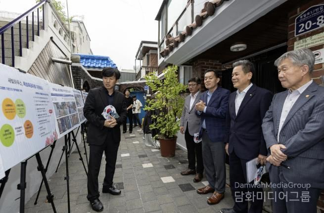 수원시와 한국보훈복지의료공단이 수원지역 독립유공자 후손의 집수리를 지원한 새빛하우스 앞에서 관계자들이 사업 설명을 듣고 있다.