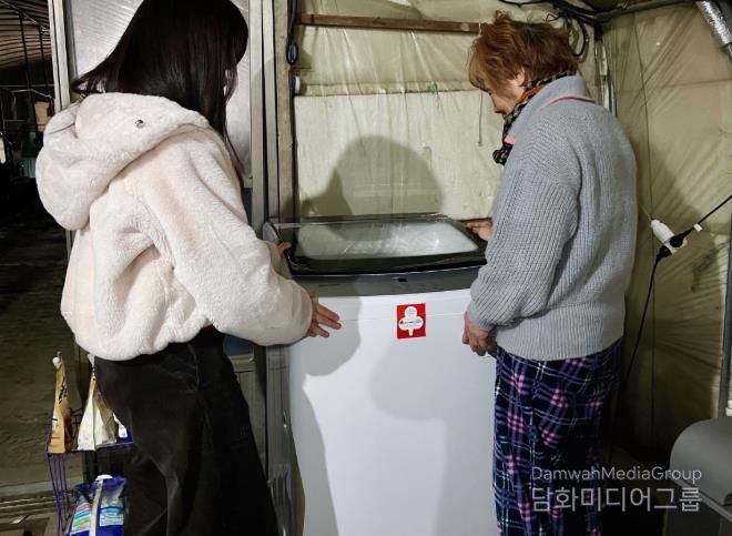 밀양시 지역사회보장협의체가 단장면에 거주하는 어르신 가구에 세탁기를 지원하고, 설치 상태를 확인하고 있다.