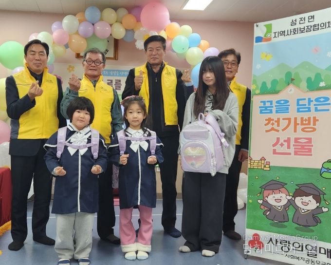 성전면 병설유치원 졸업식에서 성전면지사협 위원들이 예비 초등학생들에게 책가방을 전달 하고 있다.