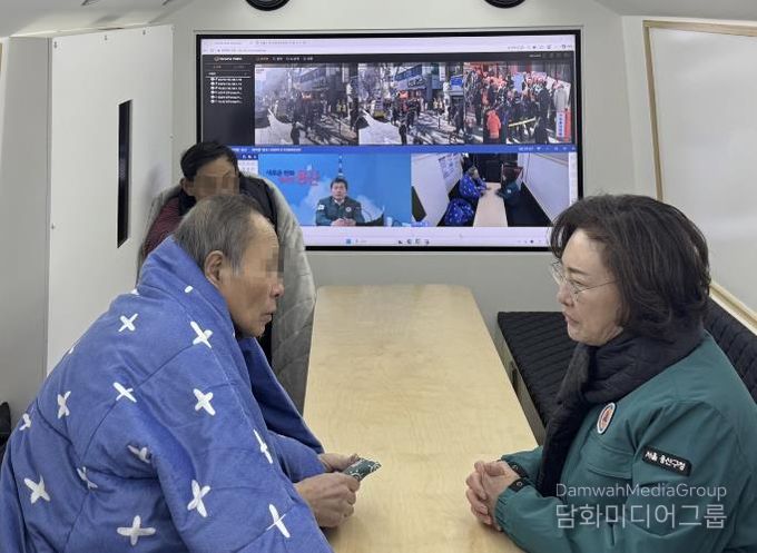 박희영 용산구청장이 재난현장지휘버스에서 임시대피 중인 청파동 화재 피해 주민들의 안전 상태를 살피고 있다.