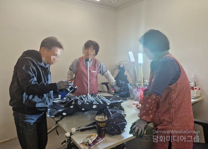 우산수리센터에서 고장난 우산을 수리하고 있고 있다.