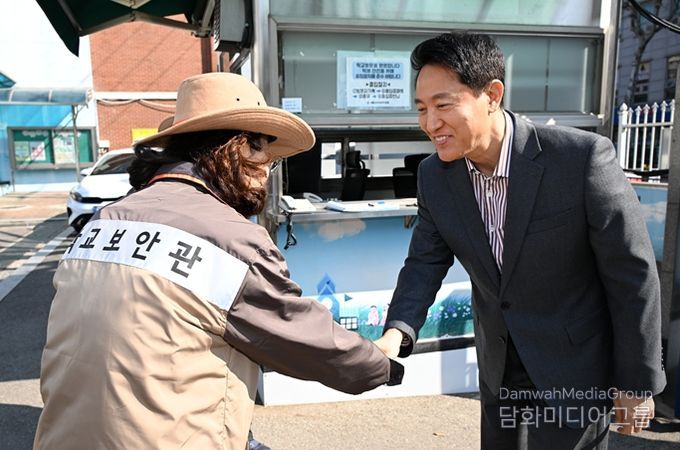 오세훈 서울시장이 13일 서울 소재 초등학교에서 학교보안관과 인사를 나누고 있다.