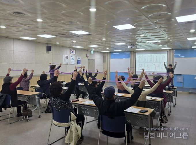 어르신들이 ‘튼튼 시니어 운동교실’에서 탄력밴드를 이용한 운동을 하고 있다.