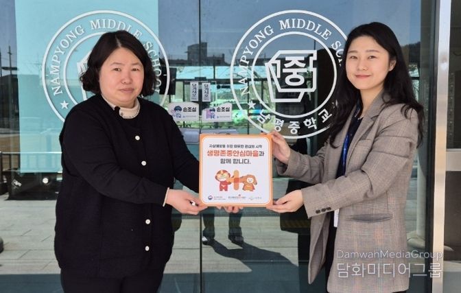 나주시보건소가 남평중학교에 생명 존중 안심마을 현판을 전달하고 있다.