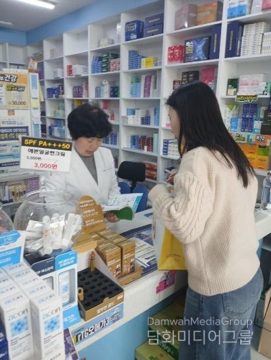 남구 치매안심약국 약사가 치매안심센터 직원의 설명을 듣고 있는 모습