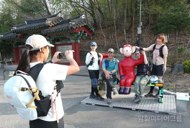관악산 등산로 입구 으뜸공원에 설치된 작품 ‘하이’와 함께 기념사진을 촬영하는 등산객들