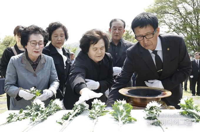 유가족과 참석자들이 제암리 순국 묘역에서 국화를 헌화하며 추모하고 있다